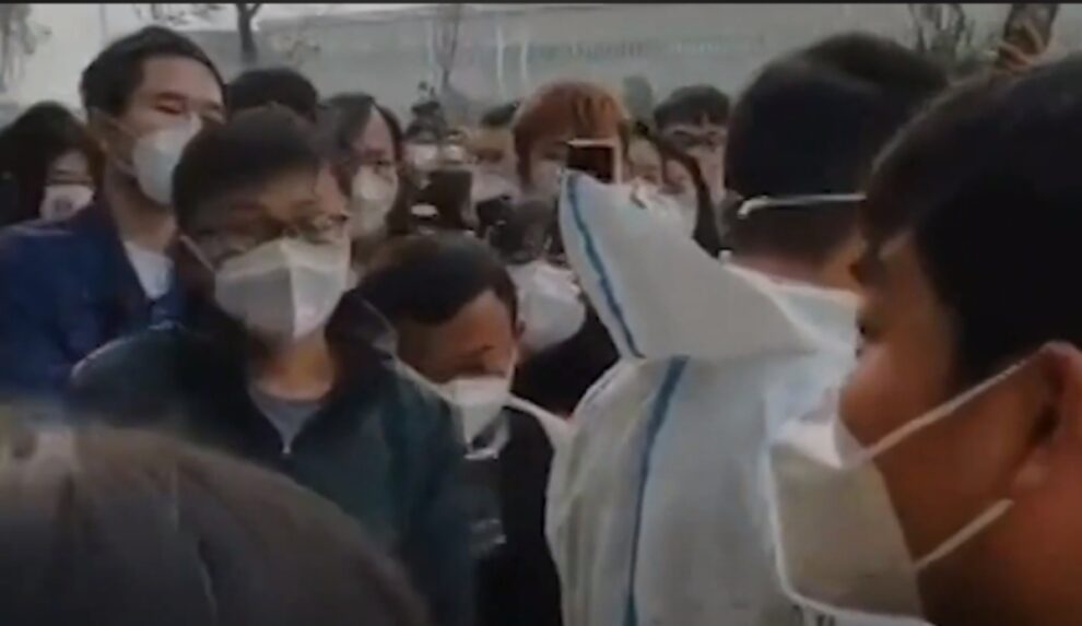 A staffer in full protective gear shouted as she handed a nurse a death certificate, their hospital in central China overflowing with Covid